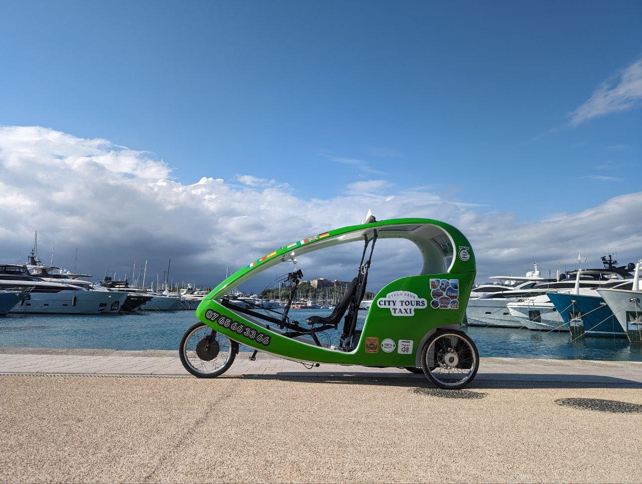 Un vélo-taxi parcourant les rues de Nice lors d'une visite guidée en août